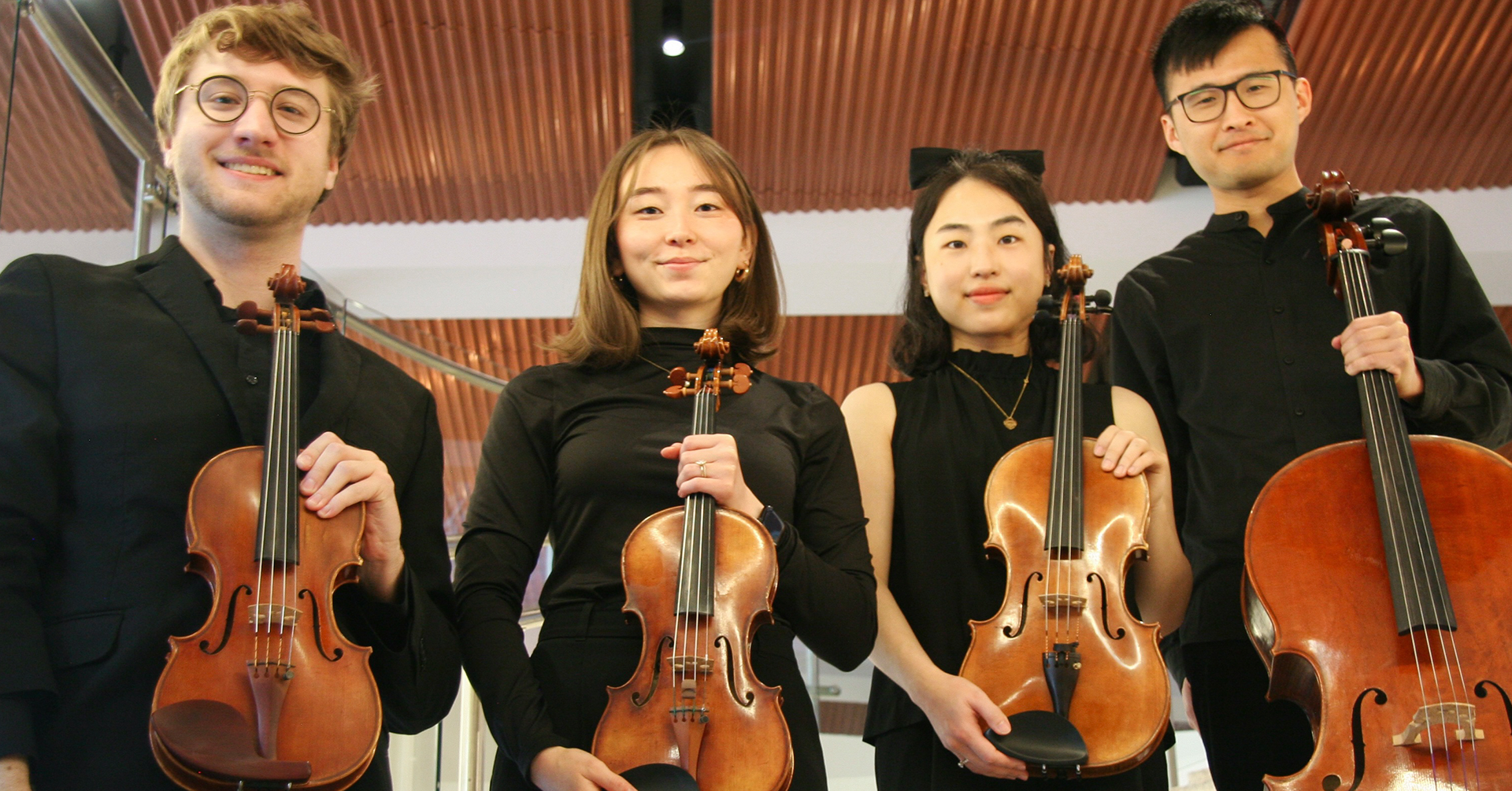 A photo of the Rabin String Quartet holding instruments.