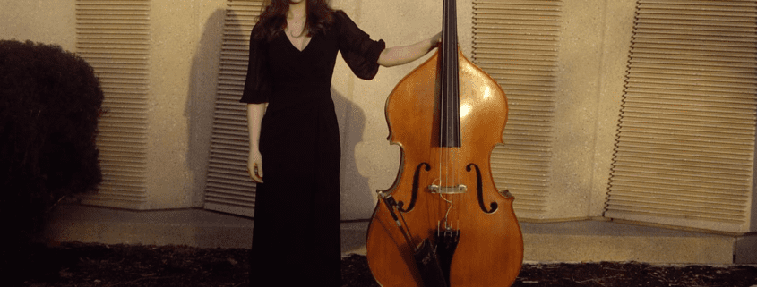 A photo of Colette Mouton standing with a double bass