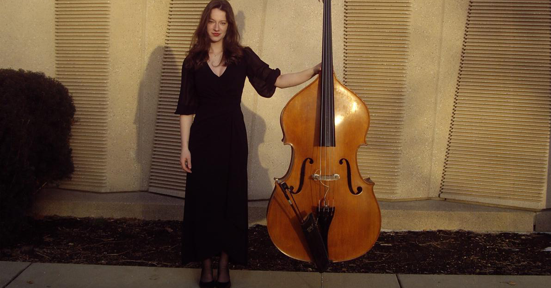 A photo of Colette Mouton standing with a double bass