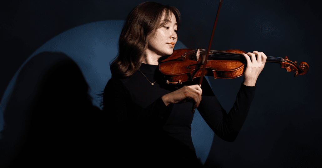 A photo of McKenna Taylor holding a violin.