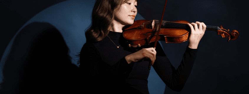 A photo of McKenna Taylor holding a violin.