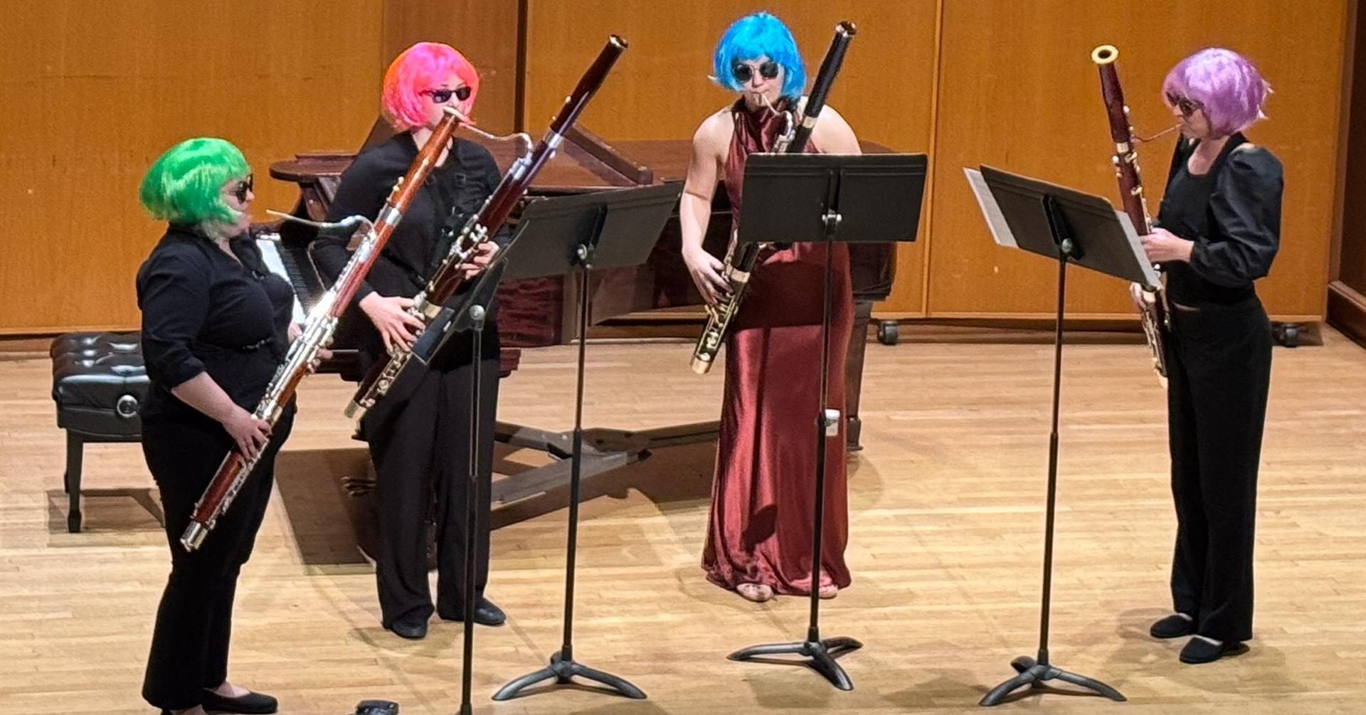 A photo of four students in the playing bassoons on stage.