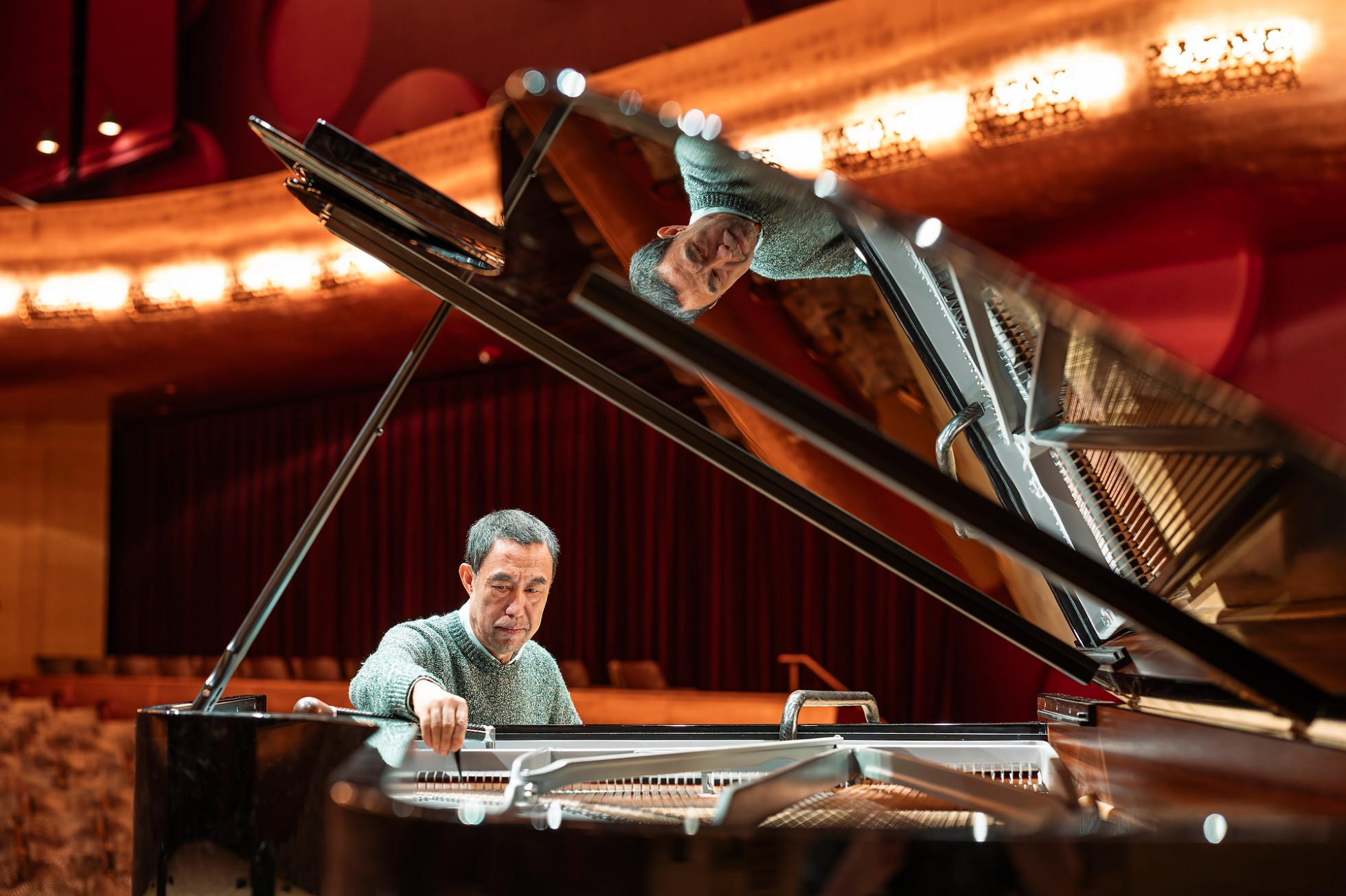 A photo of Baoli Liu working at a piano. 