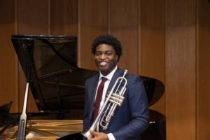 A photo of Gabriel Wade holding a trumpet.