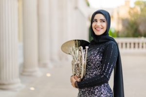 A photo of Layan Atieh holding a French horn.