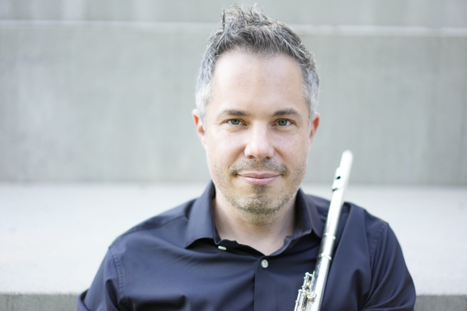 A photo of Conor Nelson holding a flute.