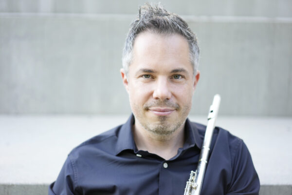 A photo of Conor Nelson holding a flute.