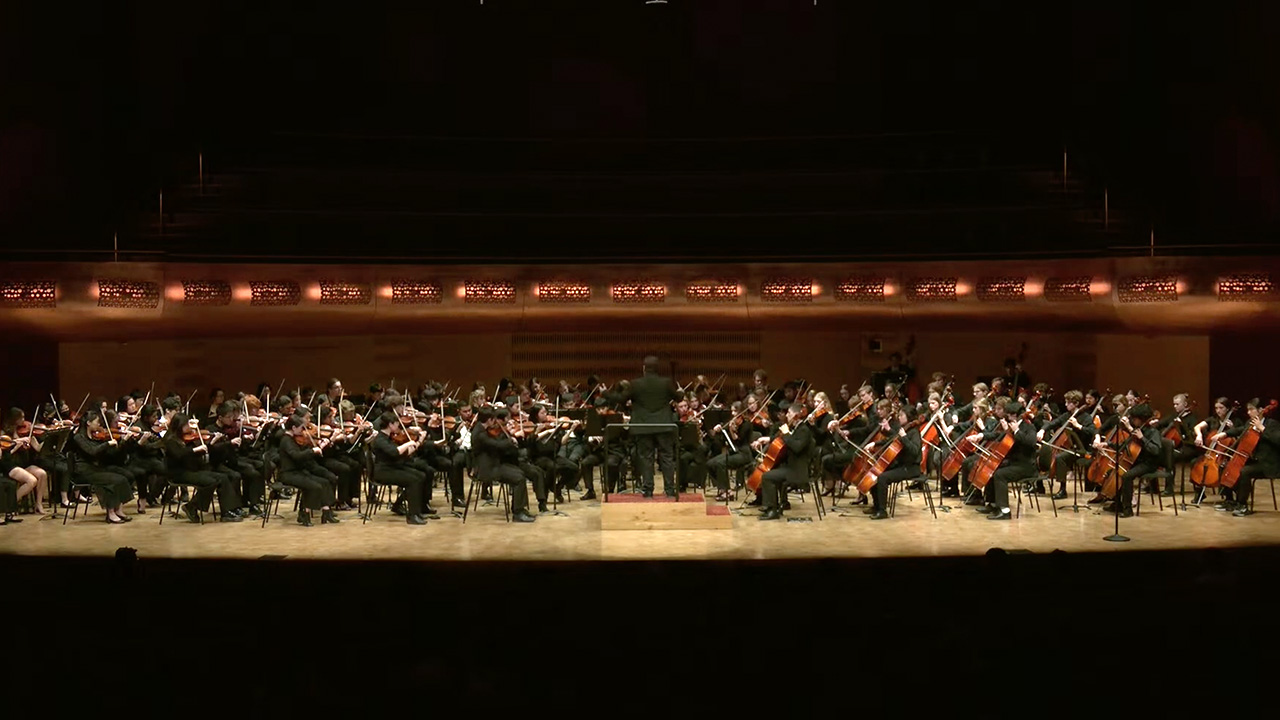 A photo of All- University String Orchestra performing on stage at the Hamel Music Center.