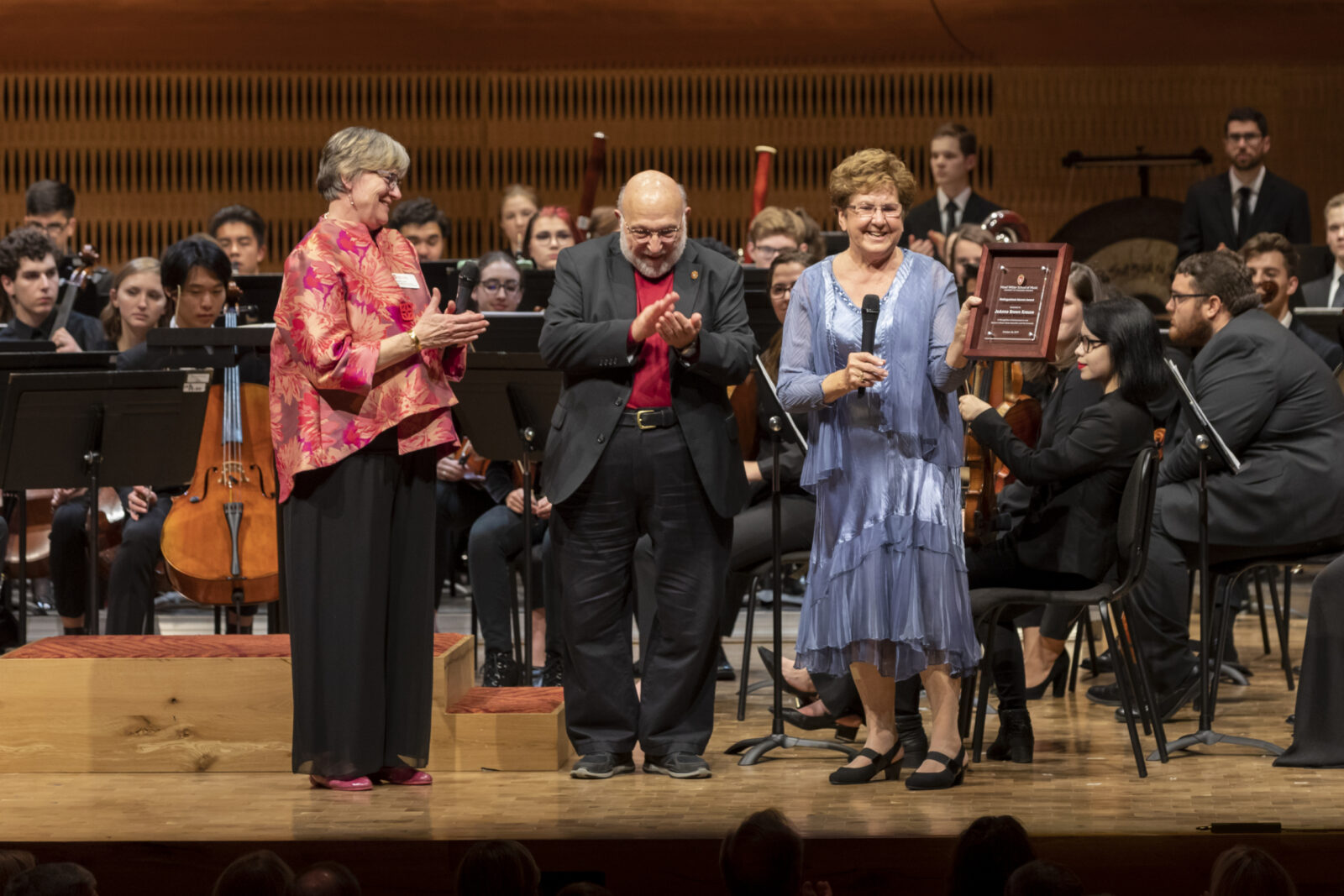 A photo of JoAnne Brown Krause accepting the Distinguished Alumni Award on stage at the Hamel Music Center.