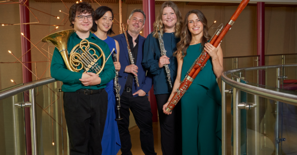 A photo of Wingra Wind Quintet holding instruments.