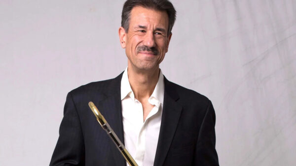 A photo of John Fedchock holding a trombone.